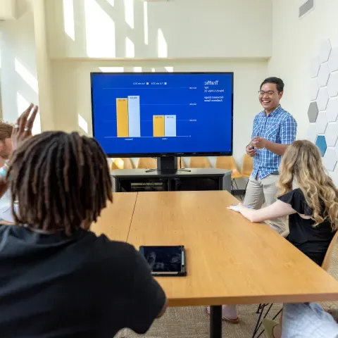 person lectures in front of students in college of business